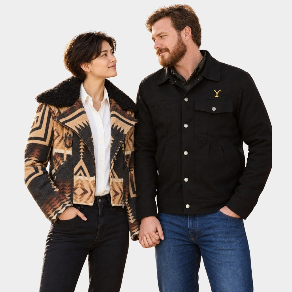 A man and a woman standing side by side against a light gray studio background. The woman wears a black-and-tan geometric patterned jacket with a black shearling-style collar over a white shirt and black jeans.